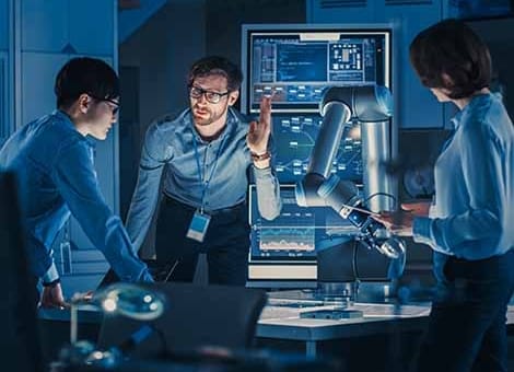 Ingenieure in einem Konstruktionslabor besprechen die Produktion mit Verwendung eines Roboters.