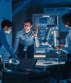 Ingenieure arbeiten an einem Roboterarm in einer intelligenten Fabrik